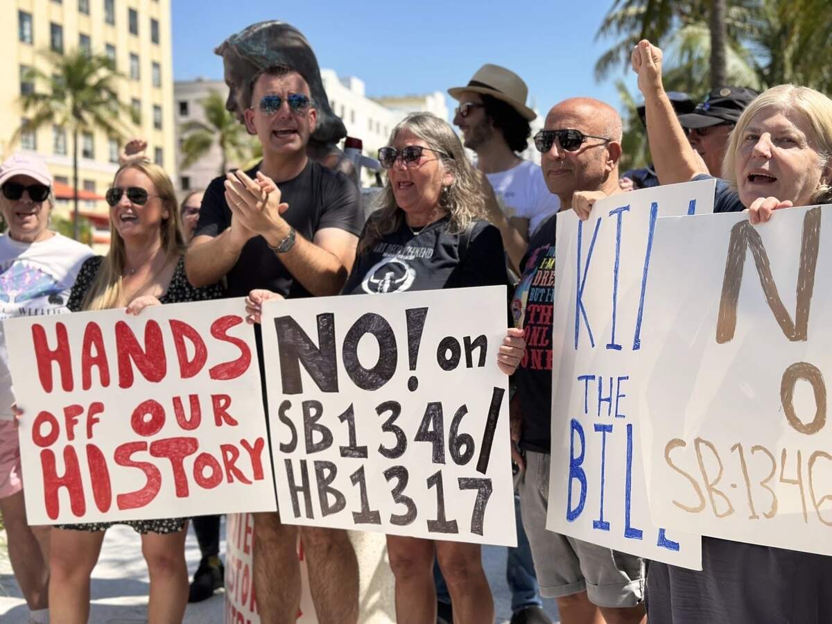Protesters, including Miami Beach Commissioner Alex Fernandez, center left, protest on Ocean Drive against the Resiliency and Safe Structures Act, which could lead to the demolition of the Savoy Hotel and other historic properties.